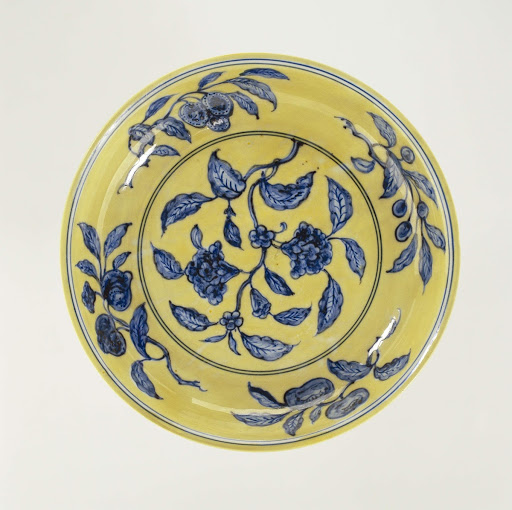 Dish with a flowering plant and fruit sprays reserved in a yellow grond - Anonymous