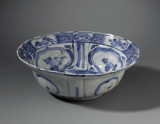 Klapmuts bowl with a butterfly near flowering plants - Anonymous