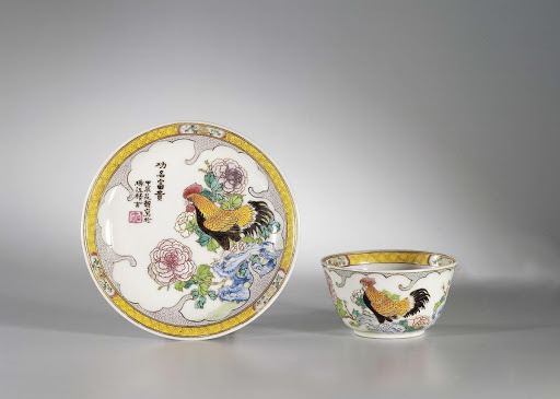 Bell-shaped cup and saucer with a cock on a rock with flowering plants - Anonymous