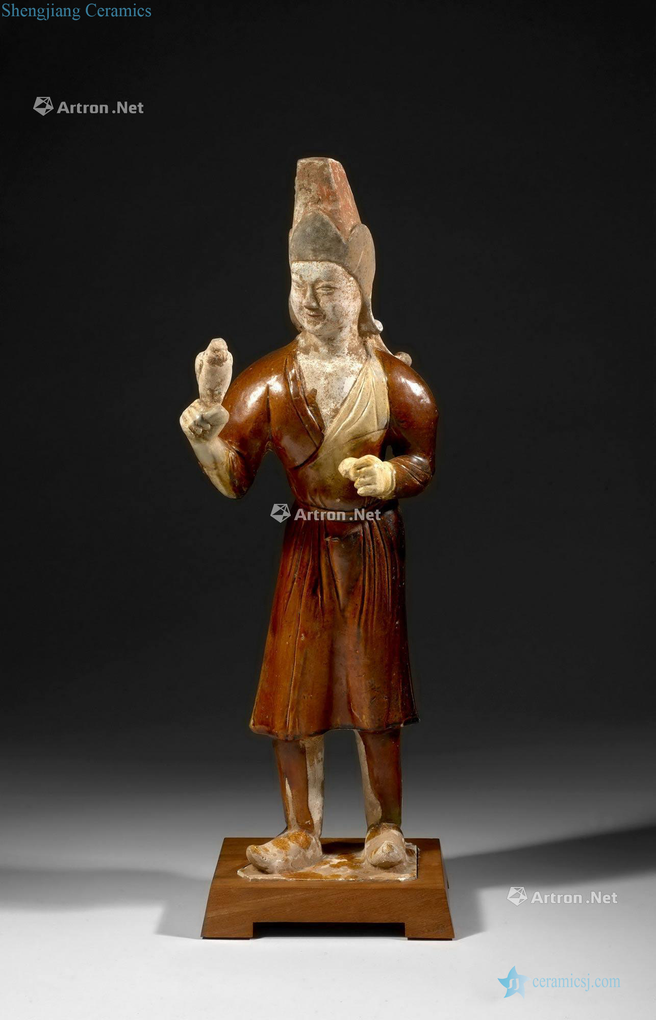 China, the Tang Dynasty (618-907), A brown and cream glazed standing figure of falconer