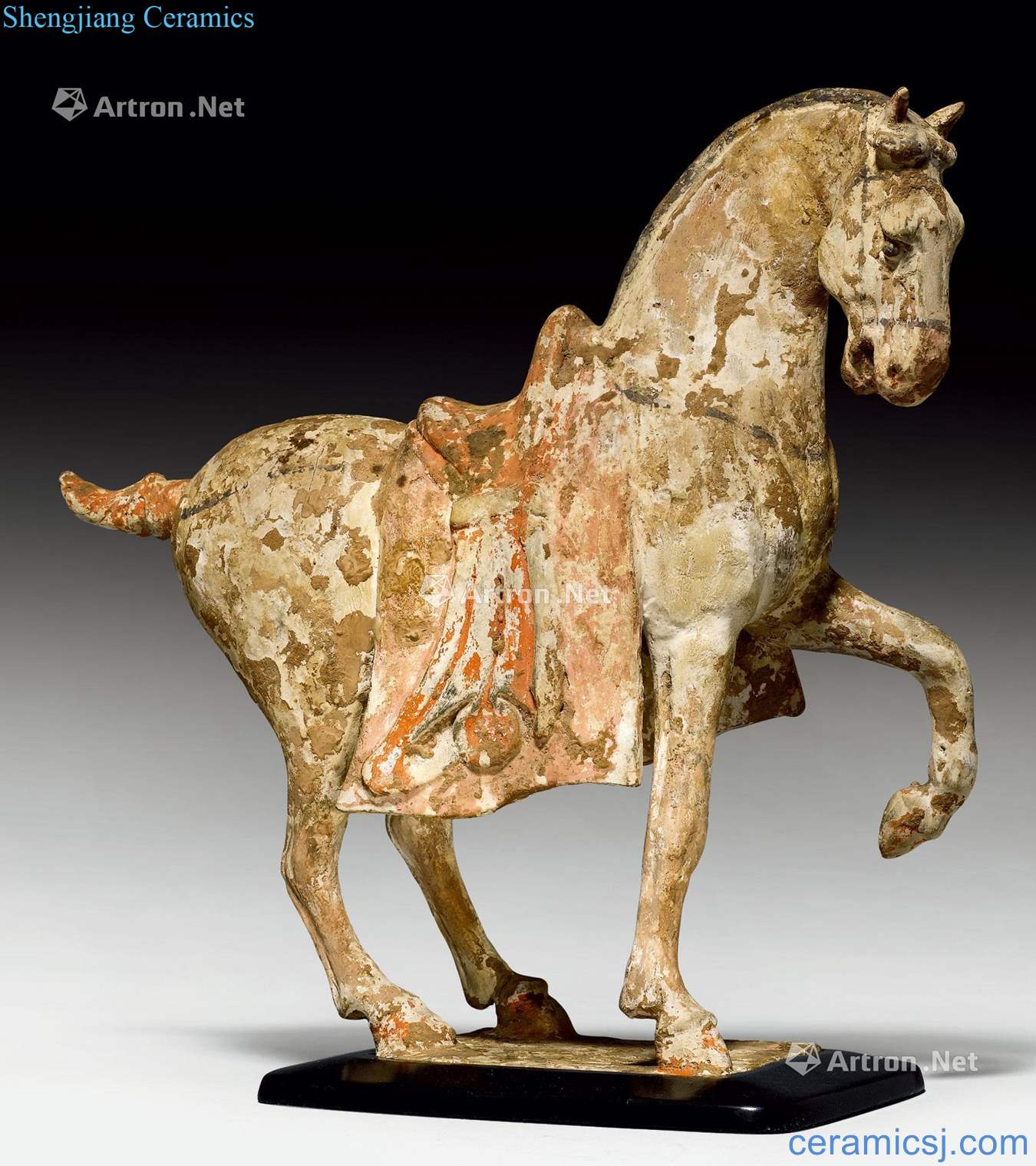 Tang dynasty POTTERY A FIGURE OF A PRANCING HORSE WITH A LARGE SHABRAQUE.
